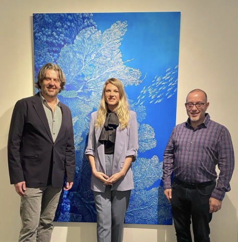 Jay Caldwell, Nikolina Kovalenko and Rob Watt in front of a painting of coral reefs.
